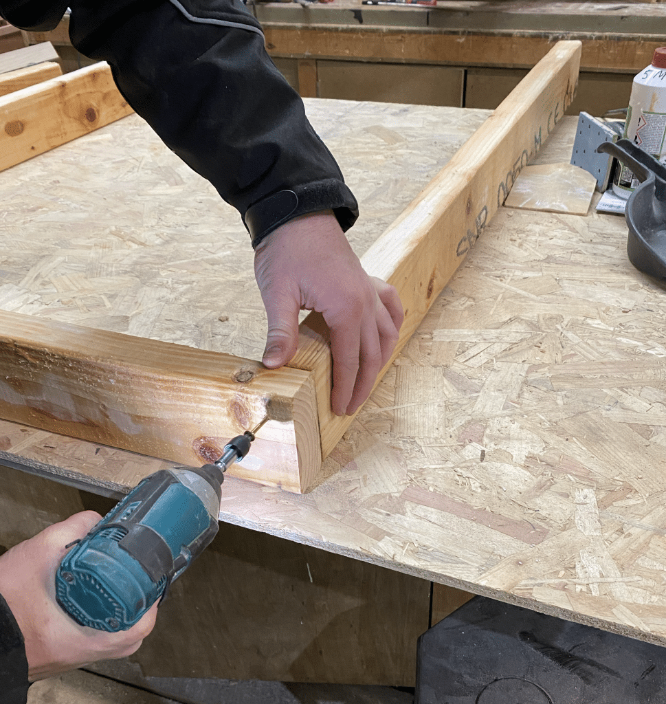 Preventing Material Separation man Screwing timber frame together